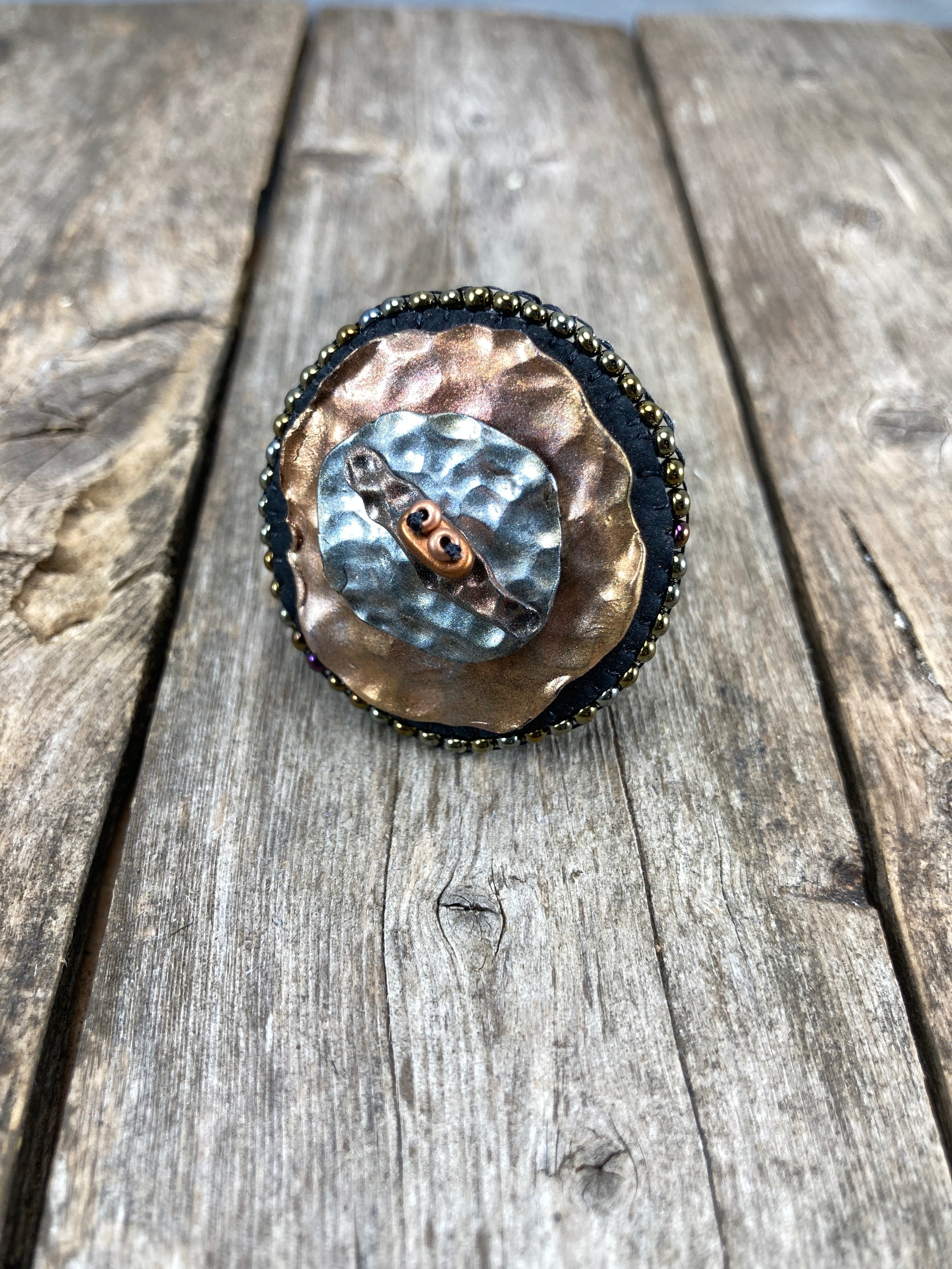 Round statement ring with abstract hammered copper and silver clay with dark gold beaded edge