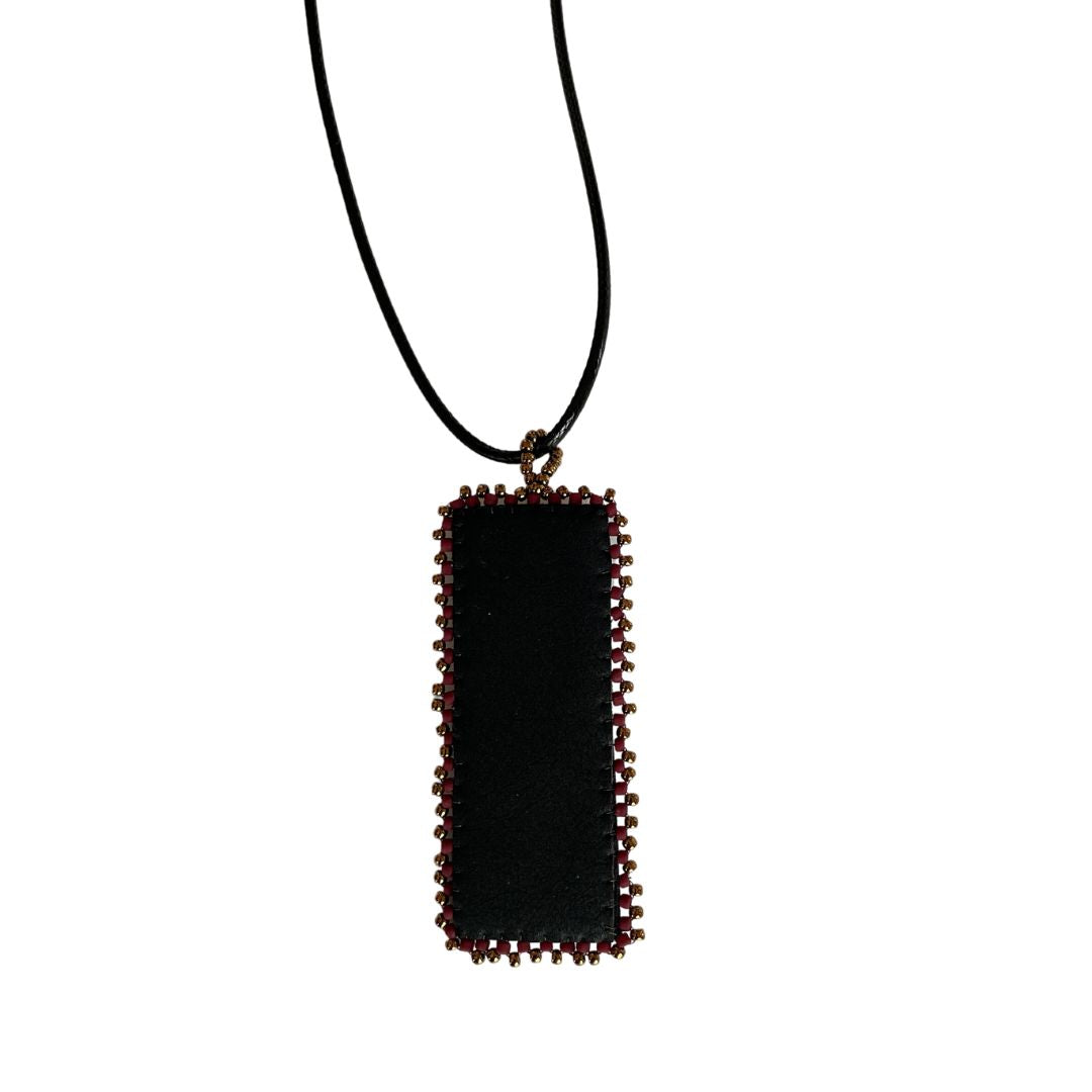 Back of red and gold Beaded faux leather rectangle pendant with beaded edge.
