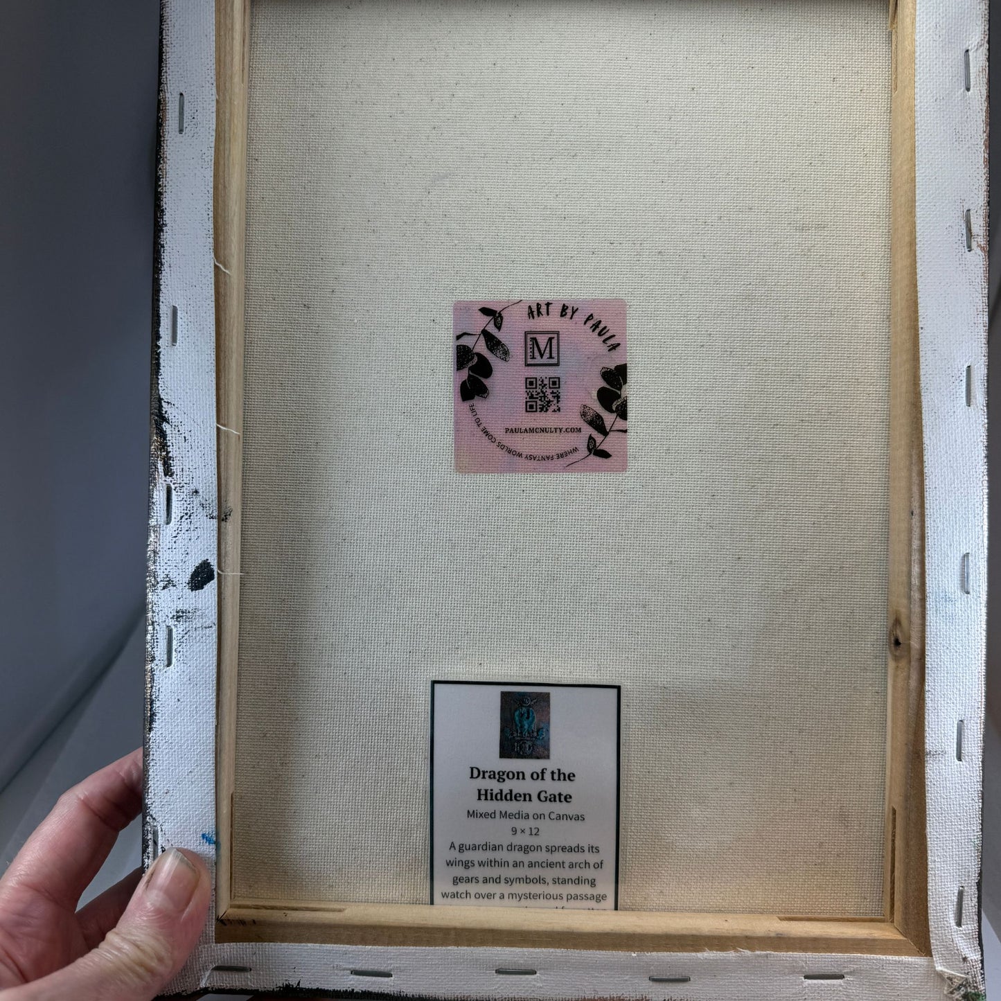 Back of a framed artwork with a visible brand label and text.