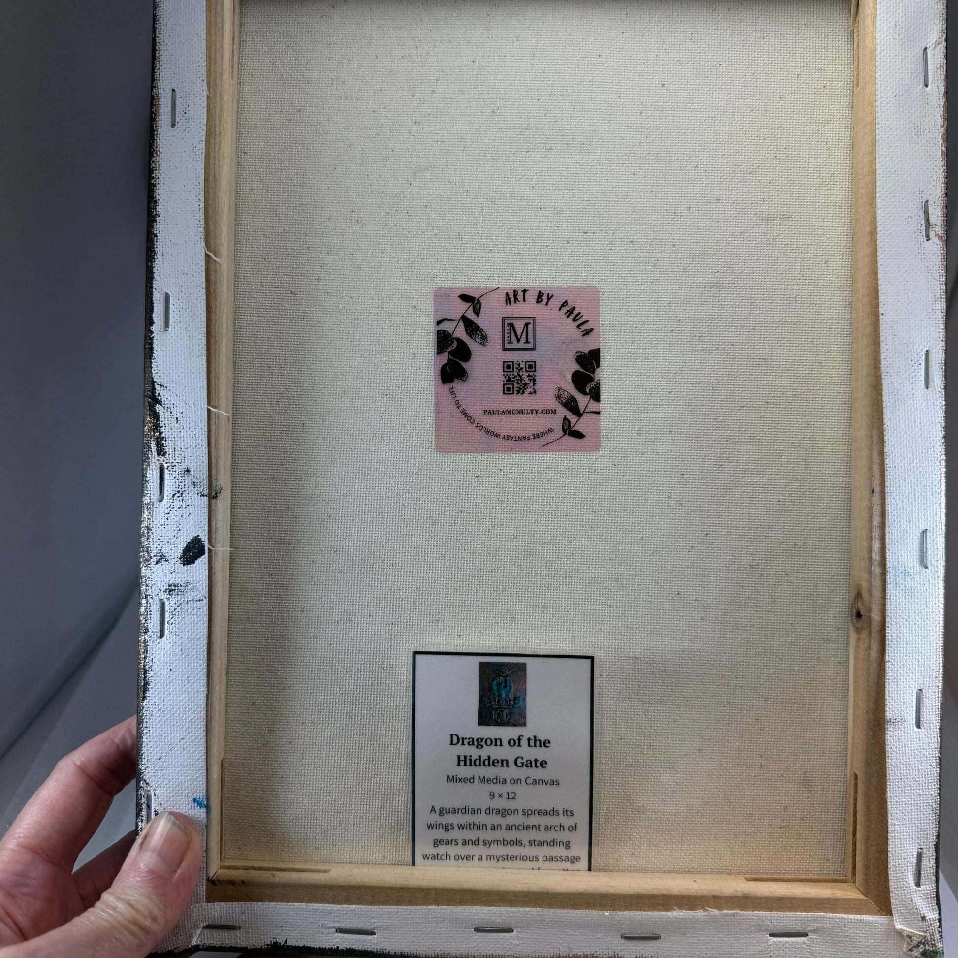 Back of a framed artwork with a visible brand label and text.