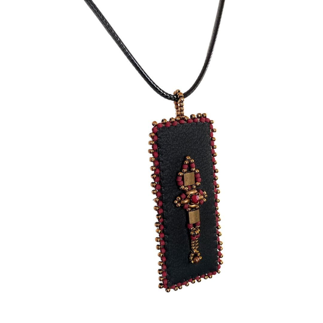 Side view of red and gold Beaded faux leather rectangle pendant with beaded edge.