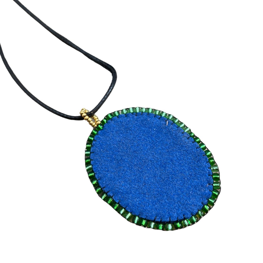 Back of Blue green and gold zentangle pattern pendant with blue and gold beaded edge.