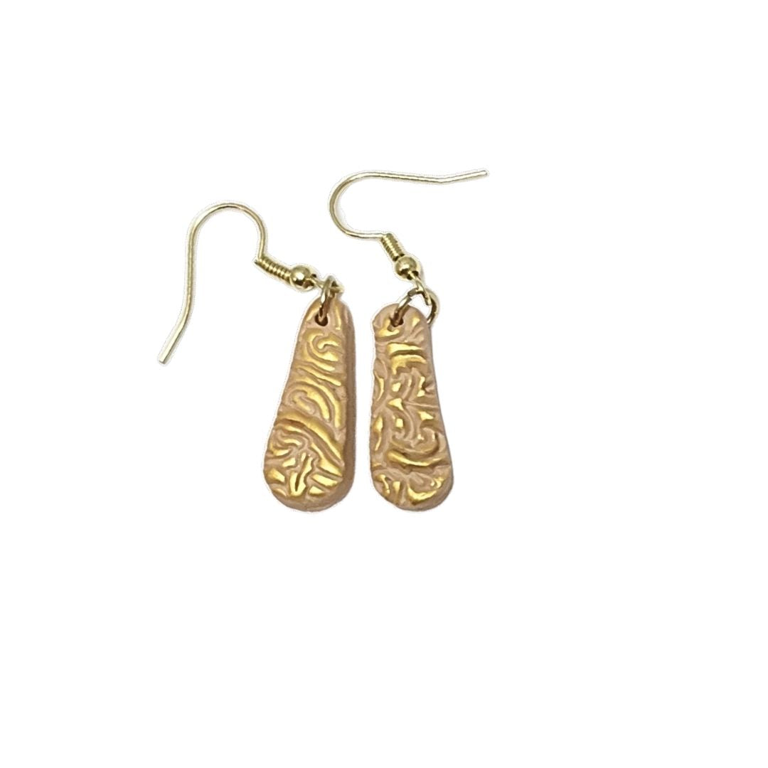 Beige teardrop earrings with gold highlights on a white background.