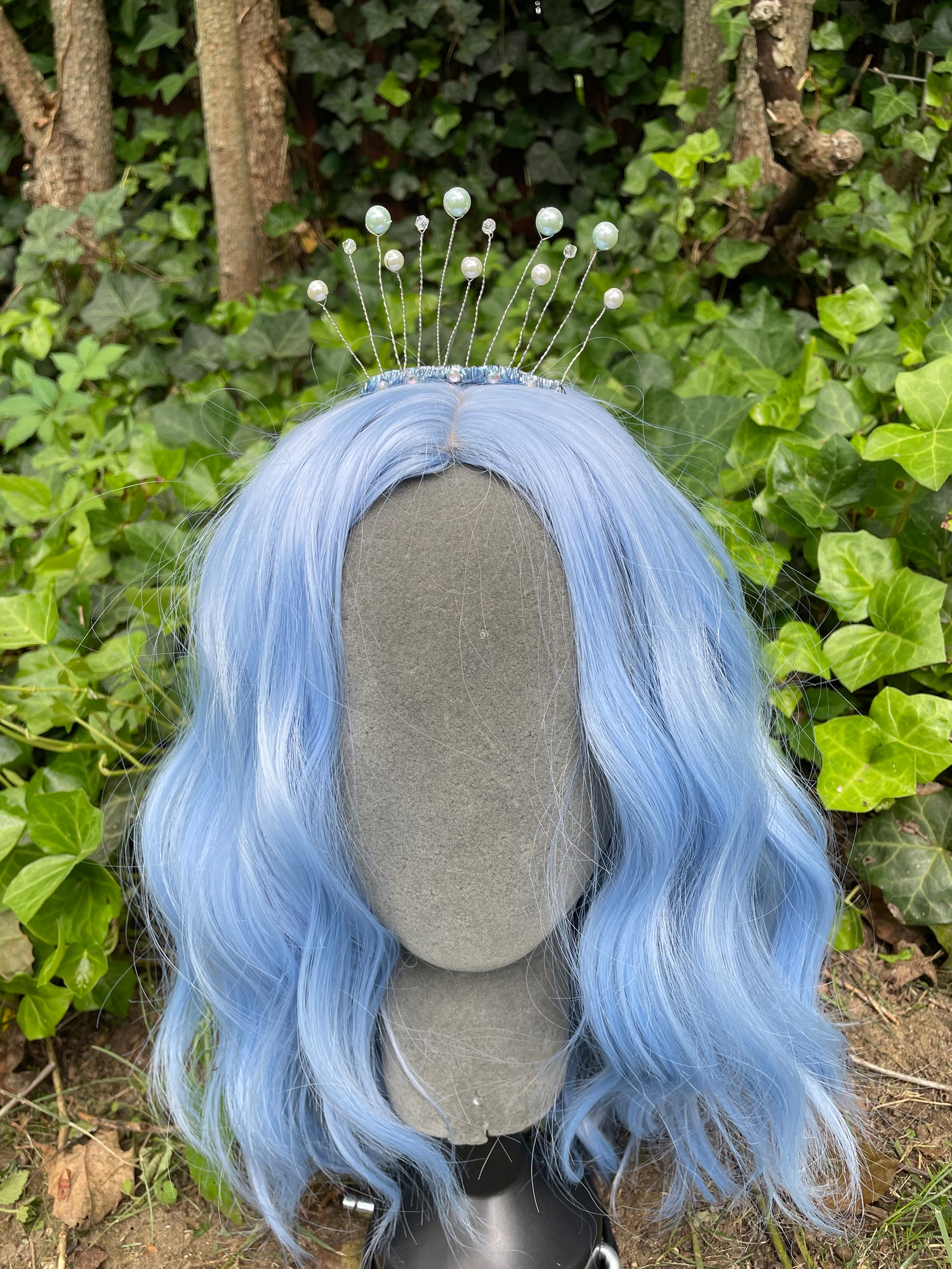 Celestial tiara with pearls on a model with a blue wig in a garden setting