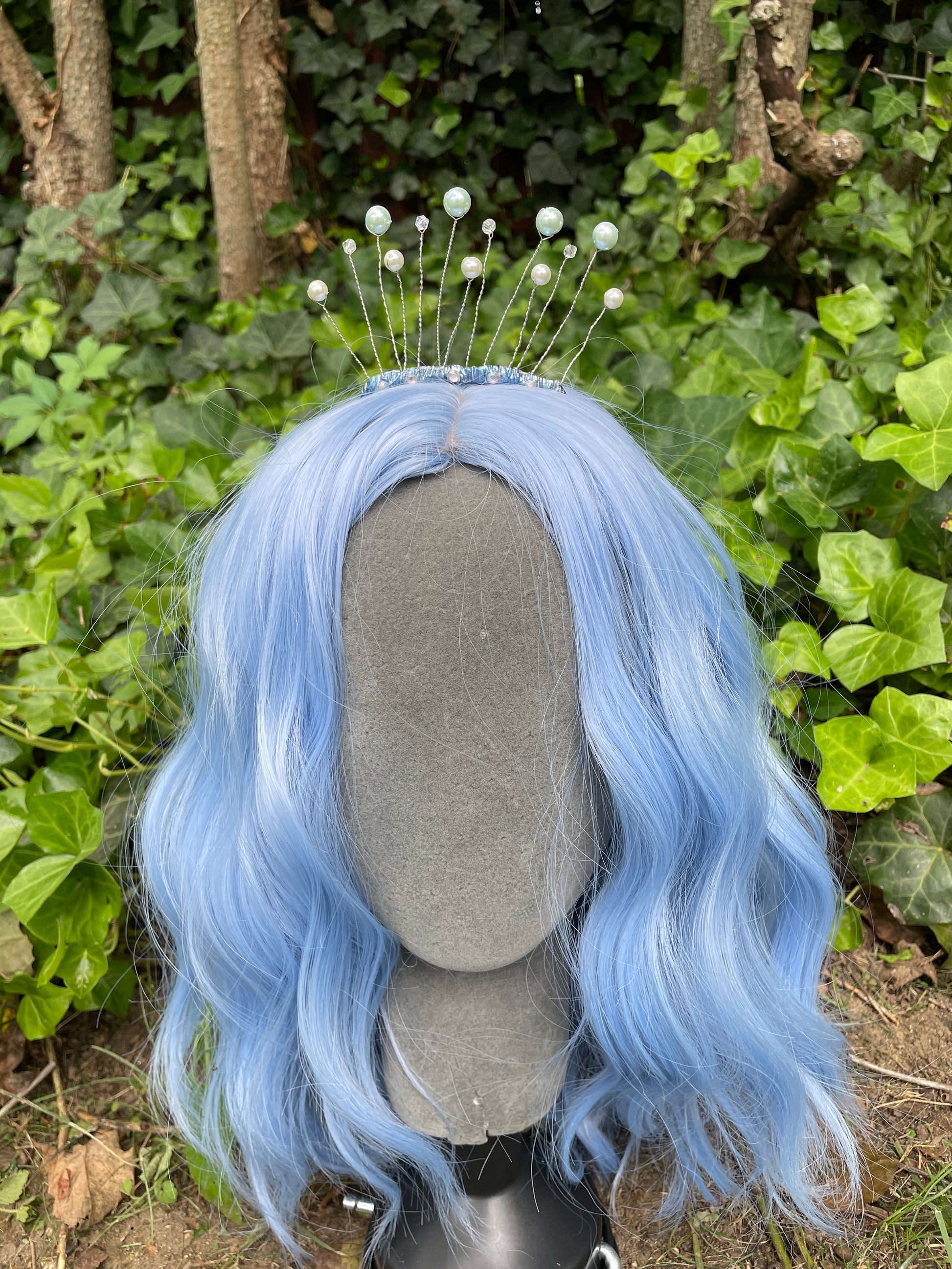 Celestial tiara with pearls on a model with a blue wig in a garden setting