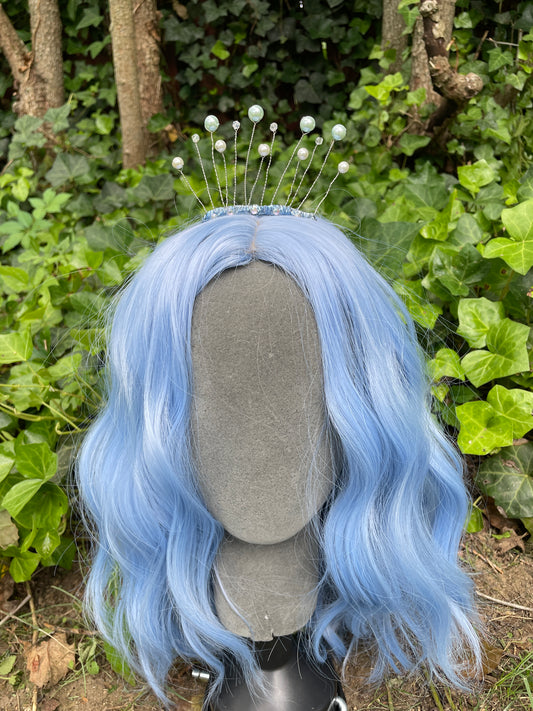 Celestial tiara with pearls on a model with a blue wig in a garden setting
