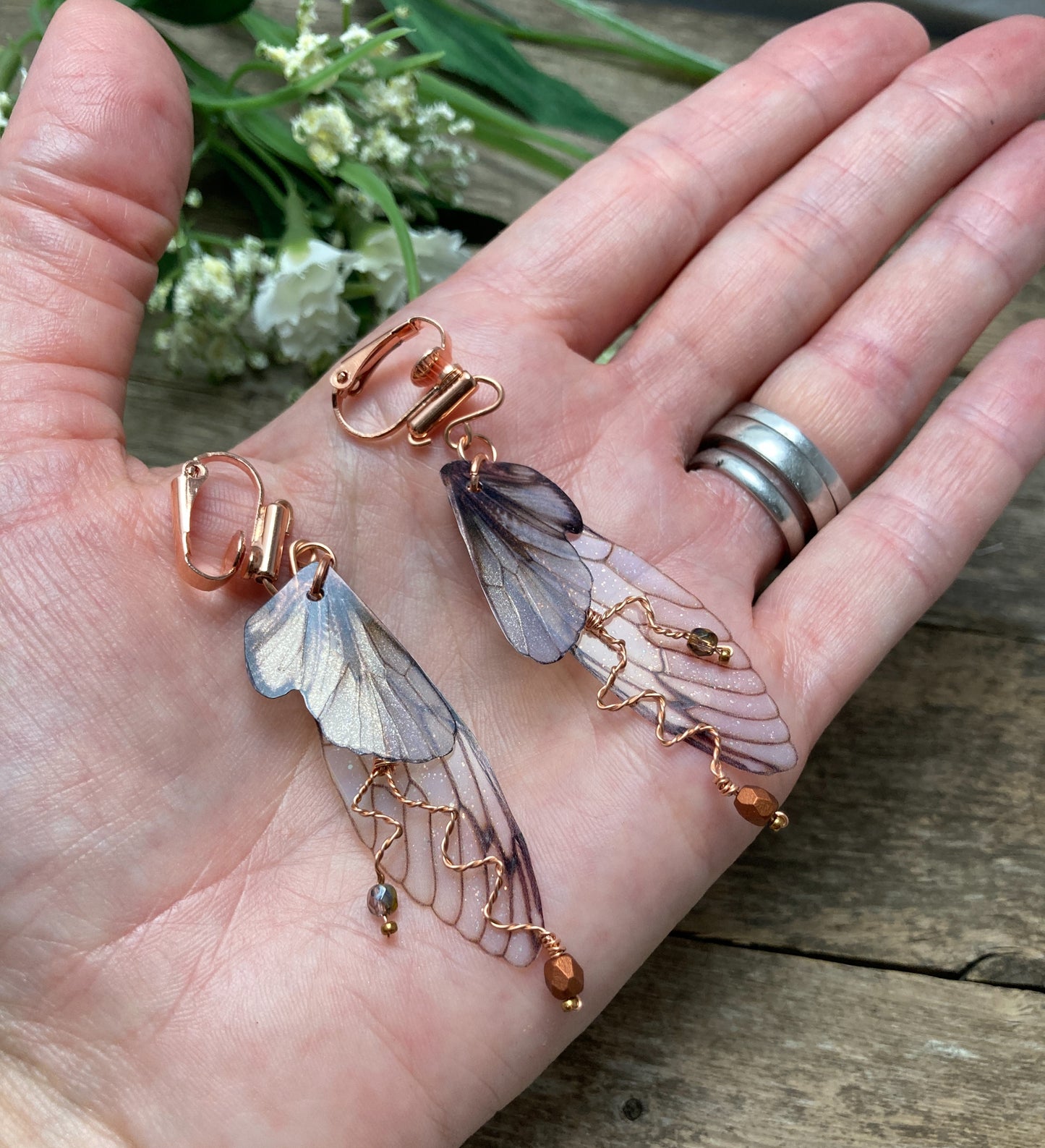 Fairy wing earrings with copper wired crystals with clip on components held in a hand