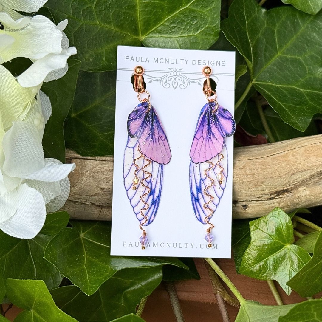 Copper finish purple fairy wing clip-on earrings with glittered double wings and twisted metal detail.