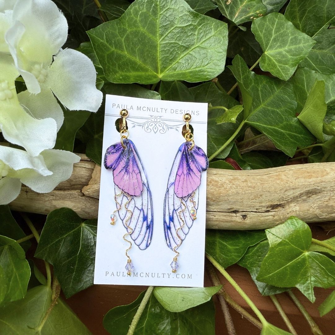 Gold finish purple butterfly wing earrings with glitter shimmer and delicate twisted wire detail.