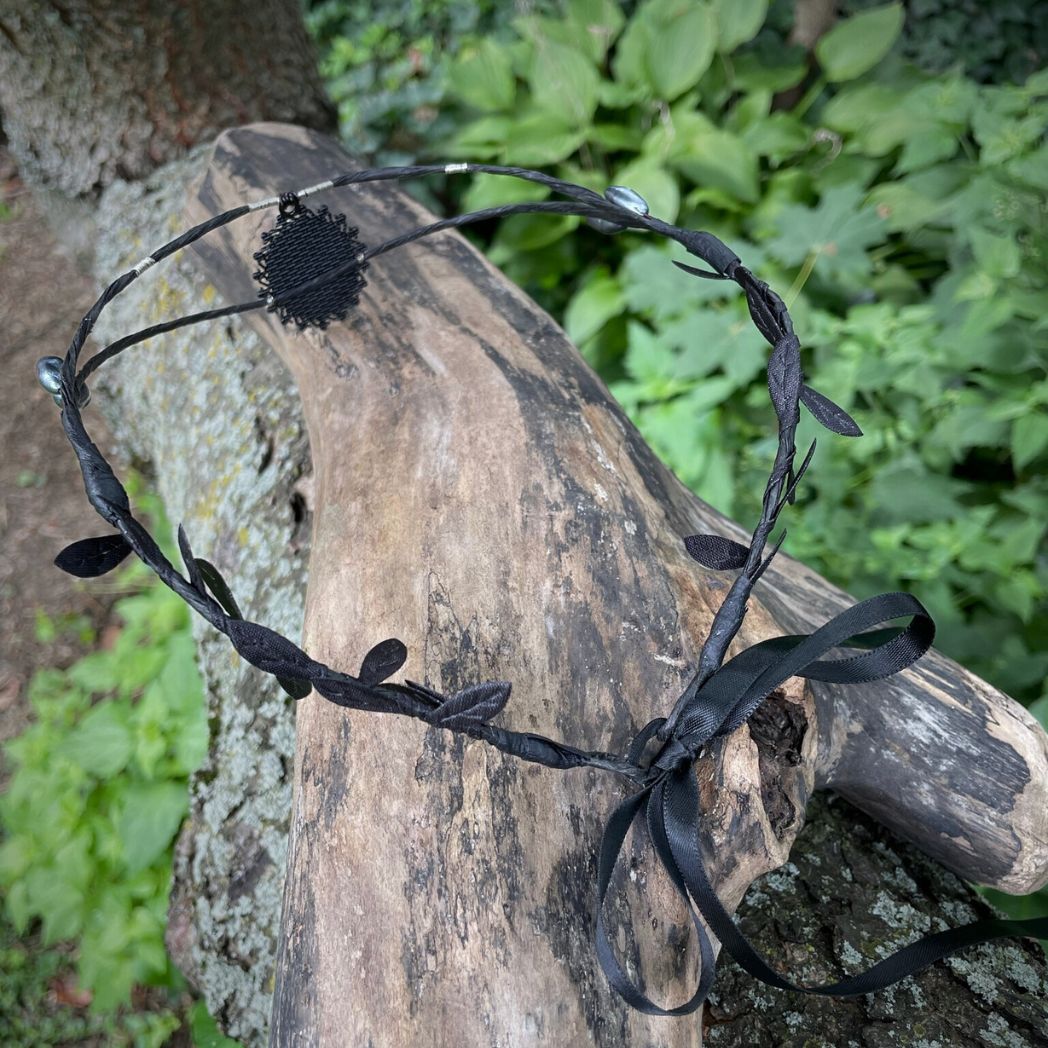 Black wire crown with oval cabochon focal ofBack of a raven and skull resting on a tree branch.