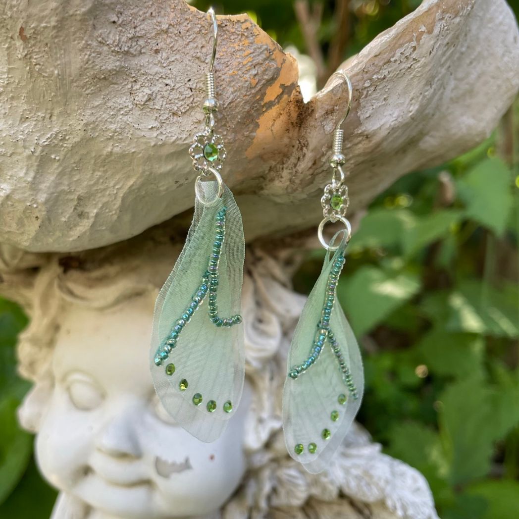 Green sheer fabric beaded butterfly wing earrings with green crystals with a flower bead connecting to the ear wires.