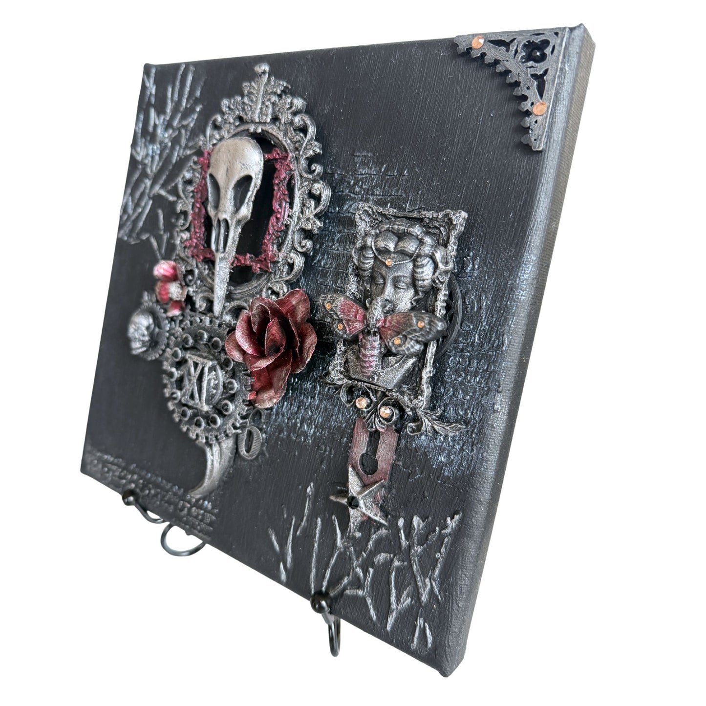 Decorative wall art with skull, roses, and ornate designs on a black background