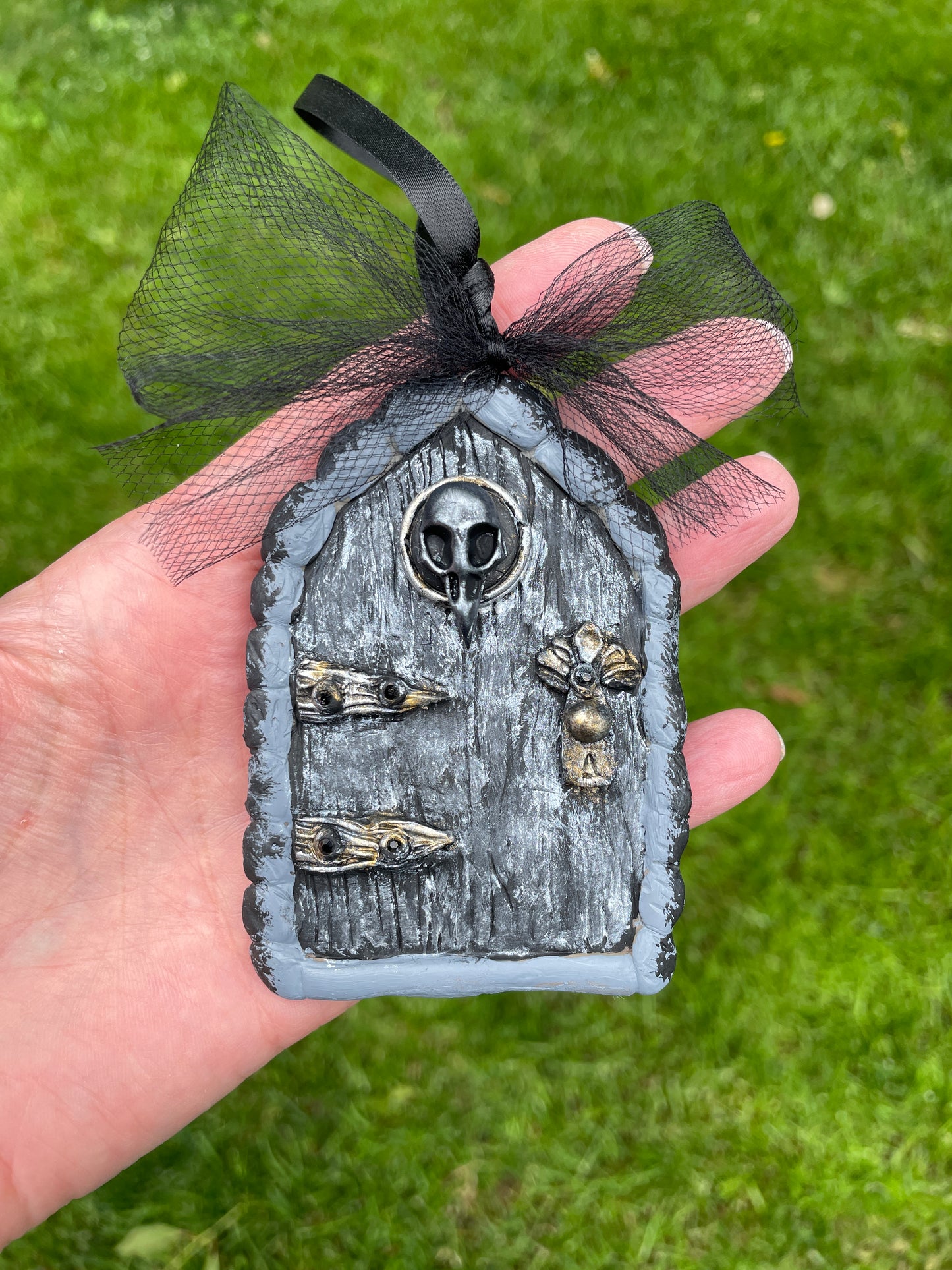 Dark fairy fairy door with raven skull motif, silver door and black tulle bow.