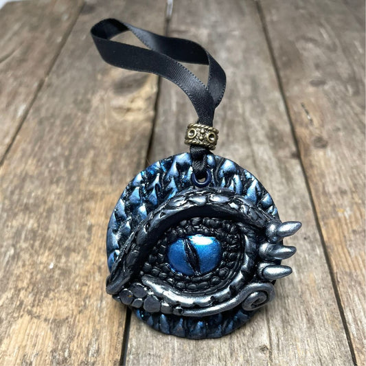 Decorative ornament with blue eye design on a wooden surface