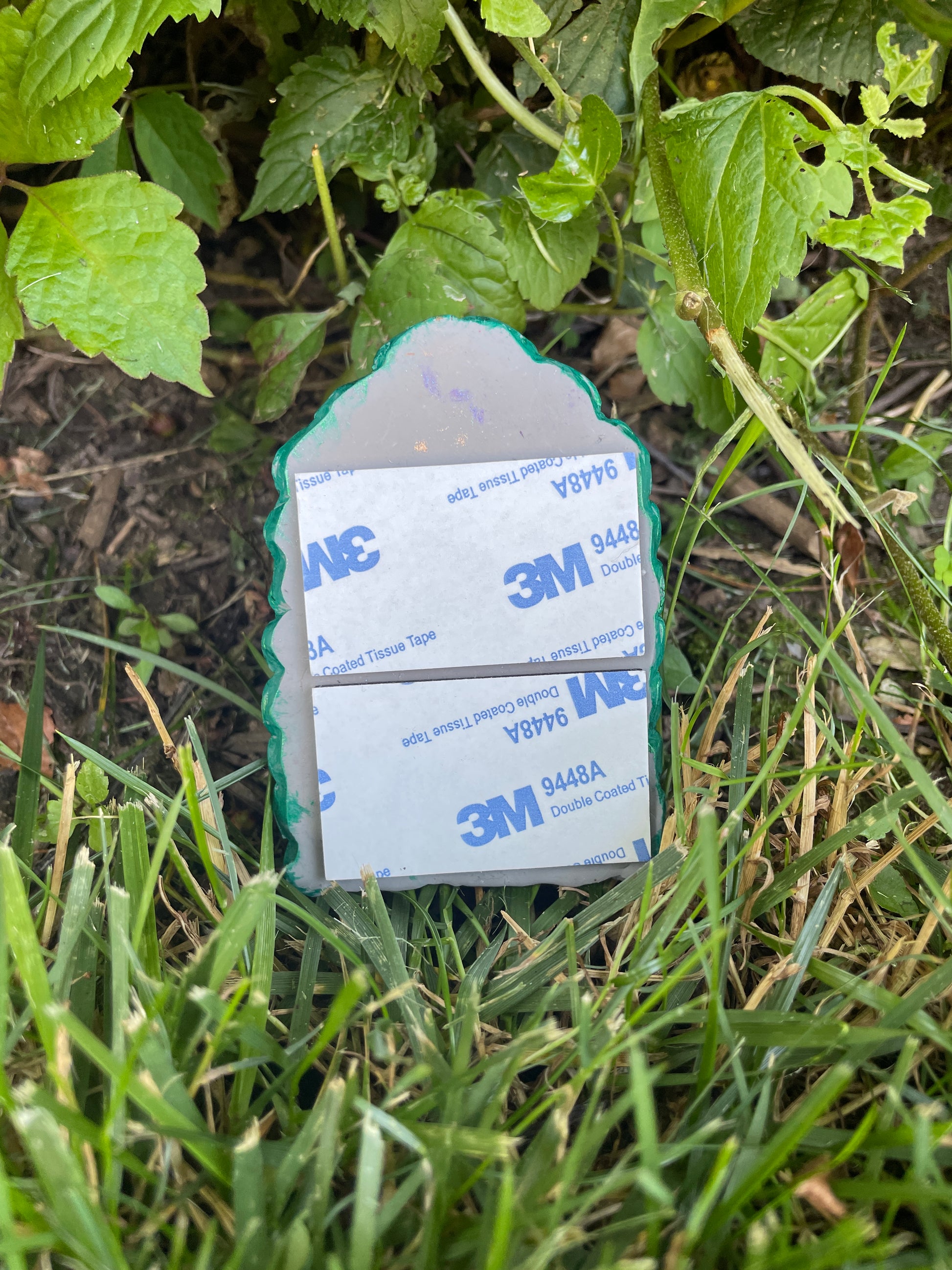 back of leaf fairy door with sticky foam pad. photo is outside  amongst greenery