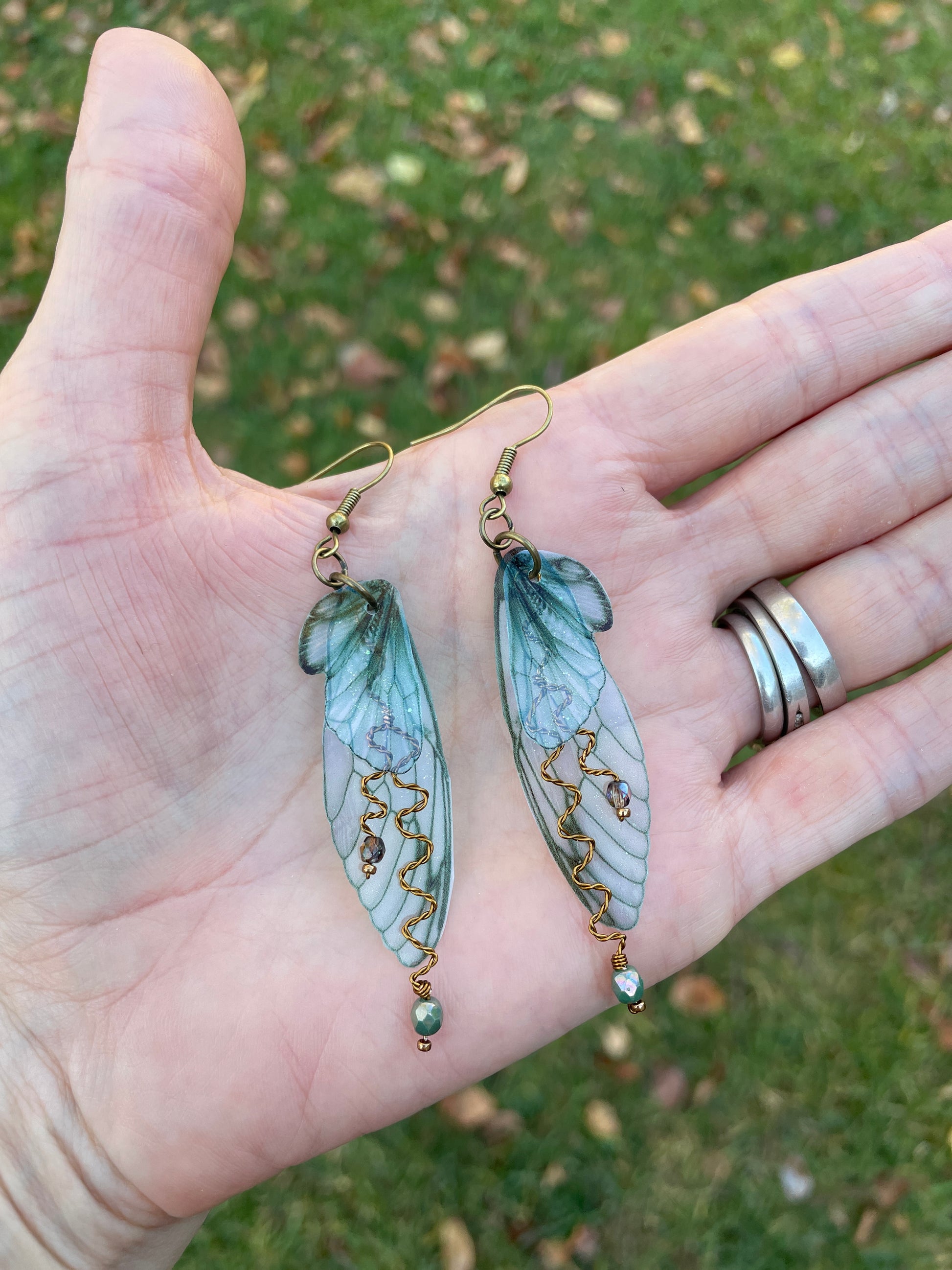 forest fairy wing earrings on a hand