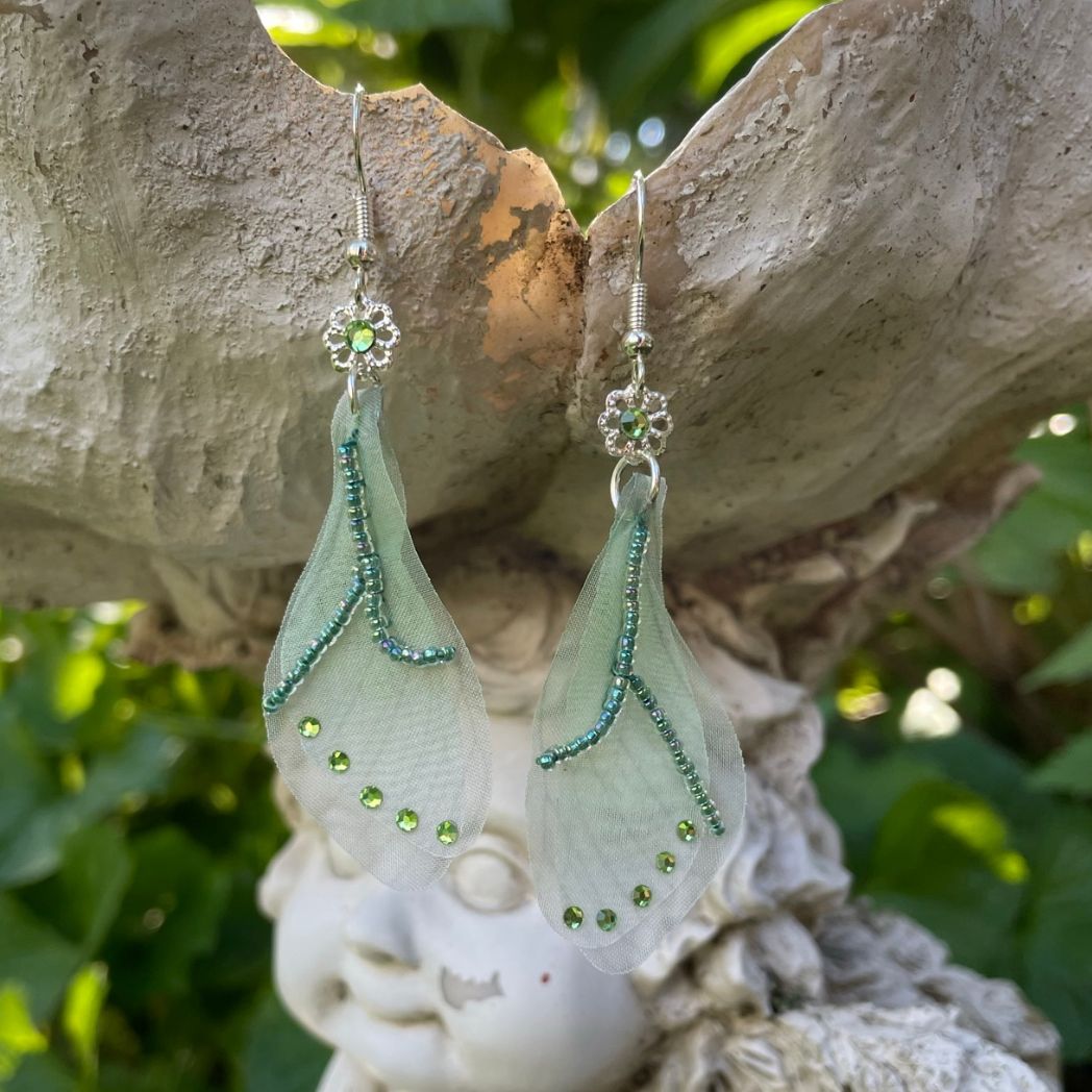 Green sheer fabric beaded butterfly wing earrings with green crystals with a flower bead connecting to the ear wires.