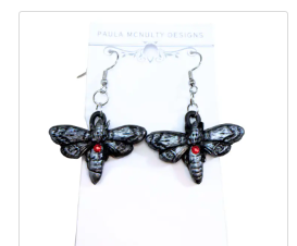 Silver death's-head moth earrings with red crystal accent on display card