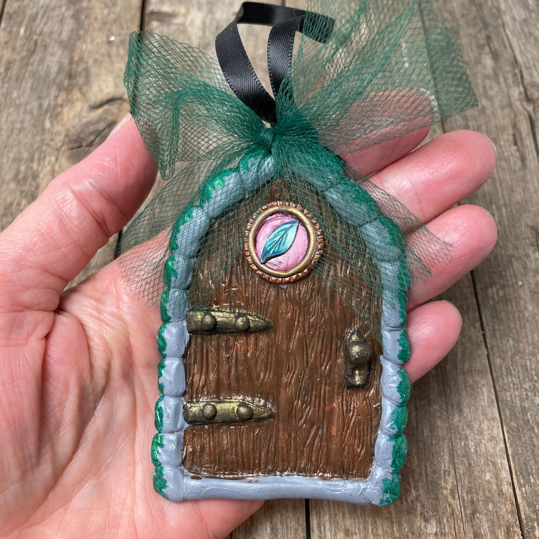 leaf motif fairy door  with green tulle bowheld in hand