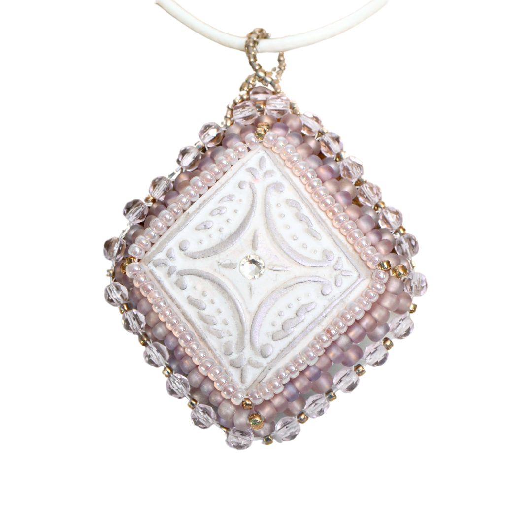 lilac beaded diamond shaped necklace on a white background.