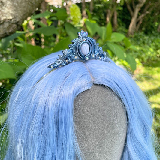 Blue mermaid tiara on a model with blue hair in a garden setting
