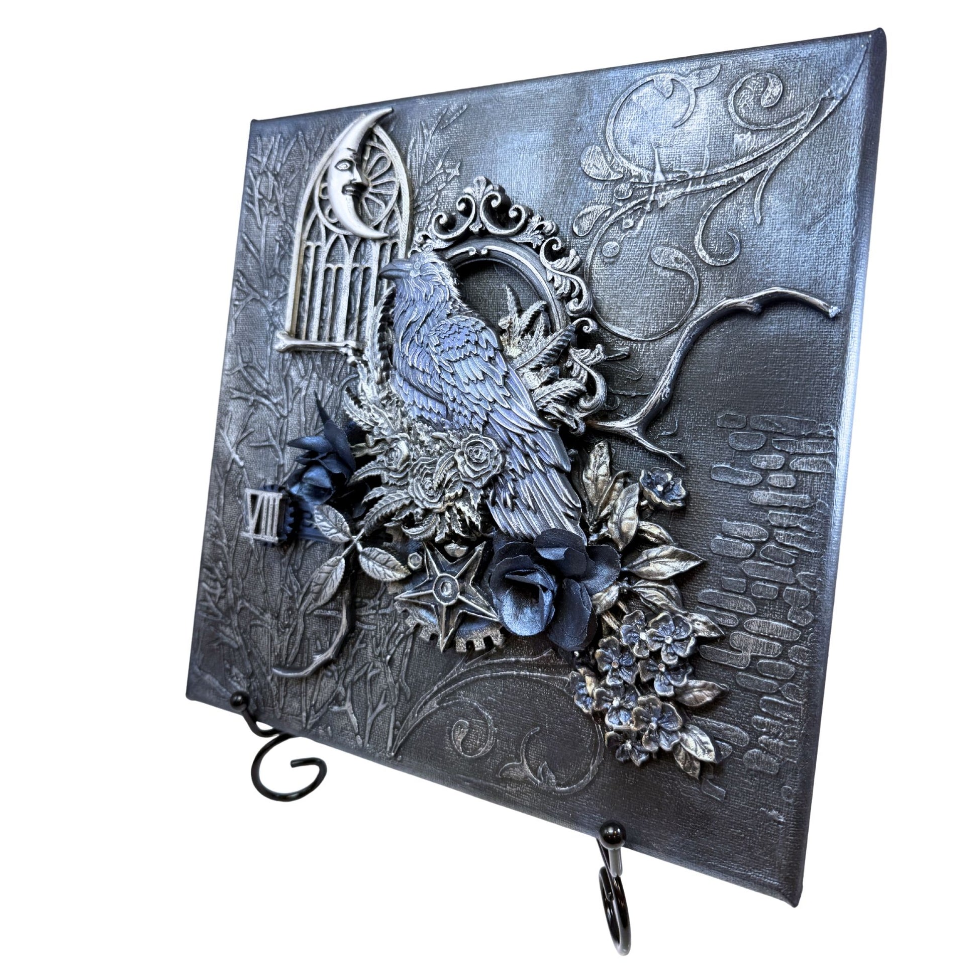 Decorative metal wall art with a bird, cage, and floral elements on a white background