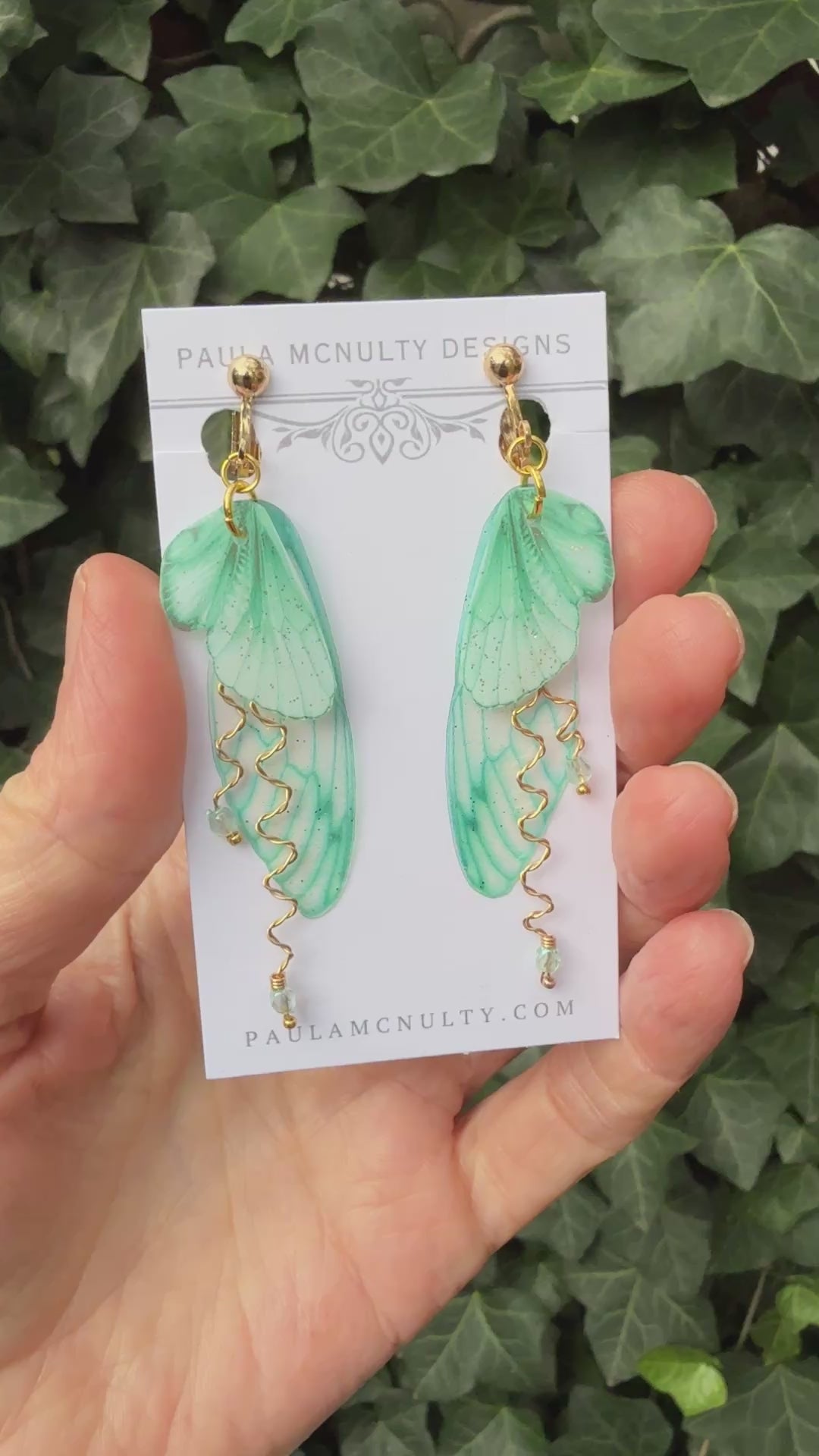 Mint green clip-on butterfly wing earrings with silver finish and comfort pads displayed on white background.