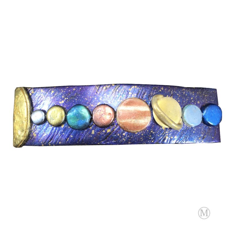 Handmade polymer clay hair barrette with purple/blue base with gold stars and hand painted solar system in clay represented in a line from the sun on far left.