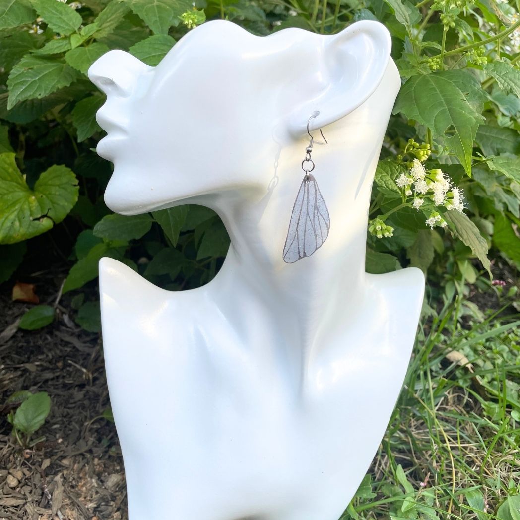 Blue gray  small wing earrings on a model bust.