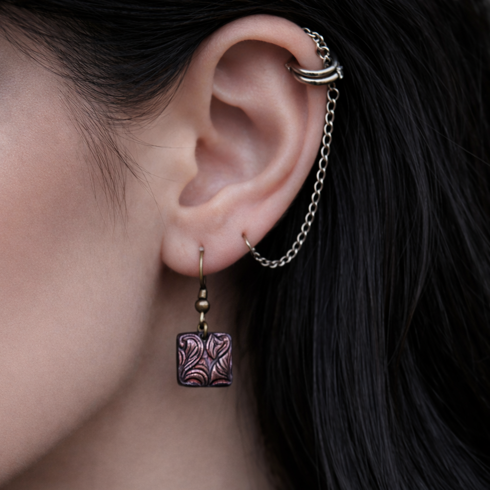 Close-up of an ear with earrings and a choker, highlighting jewelry details.