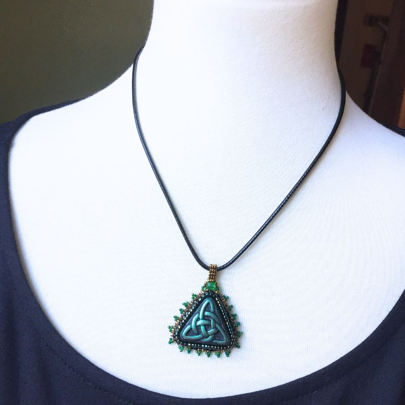 green beaded trinity pendant shown on a model.