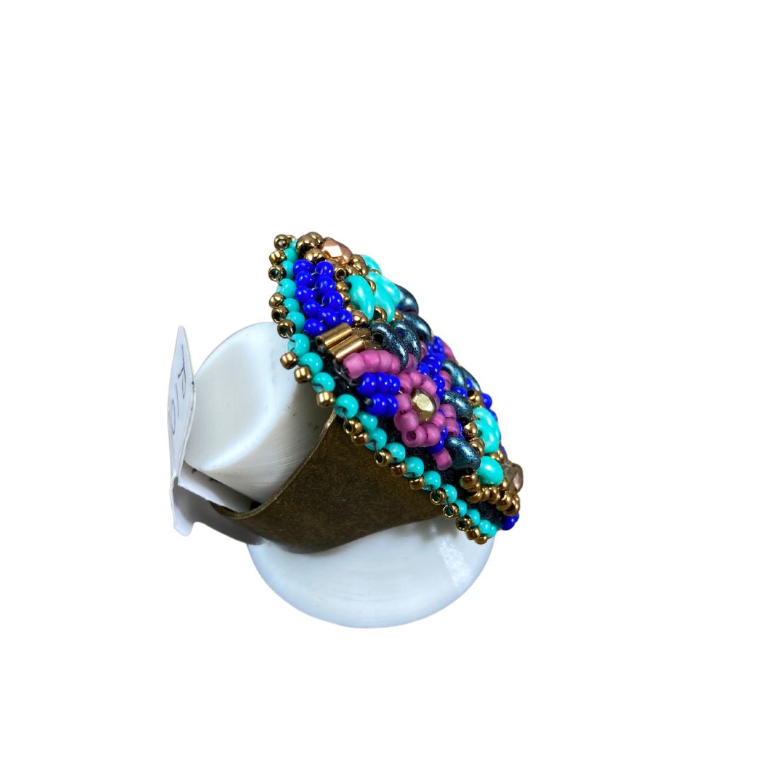 Side view of Hand beaded rectangle ring with pink and turquoise flower with bronze crystals and with gold and royal blue glass bead details.