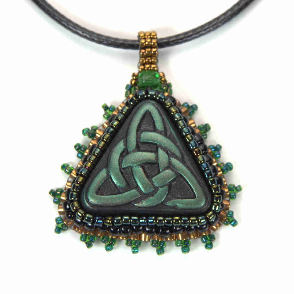 Green celtic trinity knot pendant with black, iradescent, and gold bezel and bail