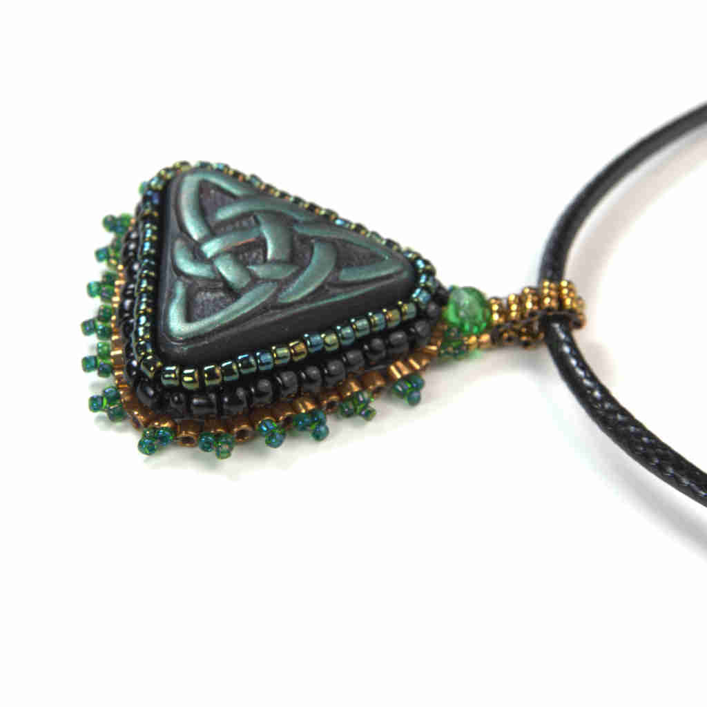 Green celtic trinity knot pendant with black, iradescent, and gold bezel and bail