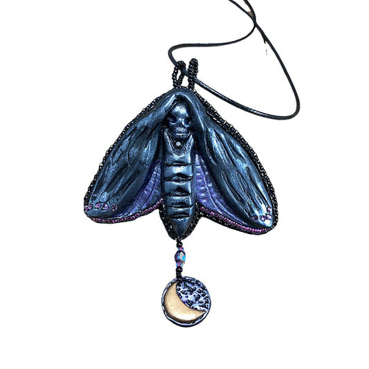 Silver and purple Death Head Moth pendant made with black polymer clay with a round charm with a crescent moon. 
