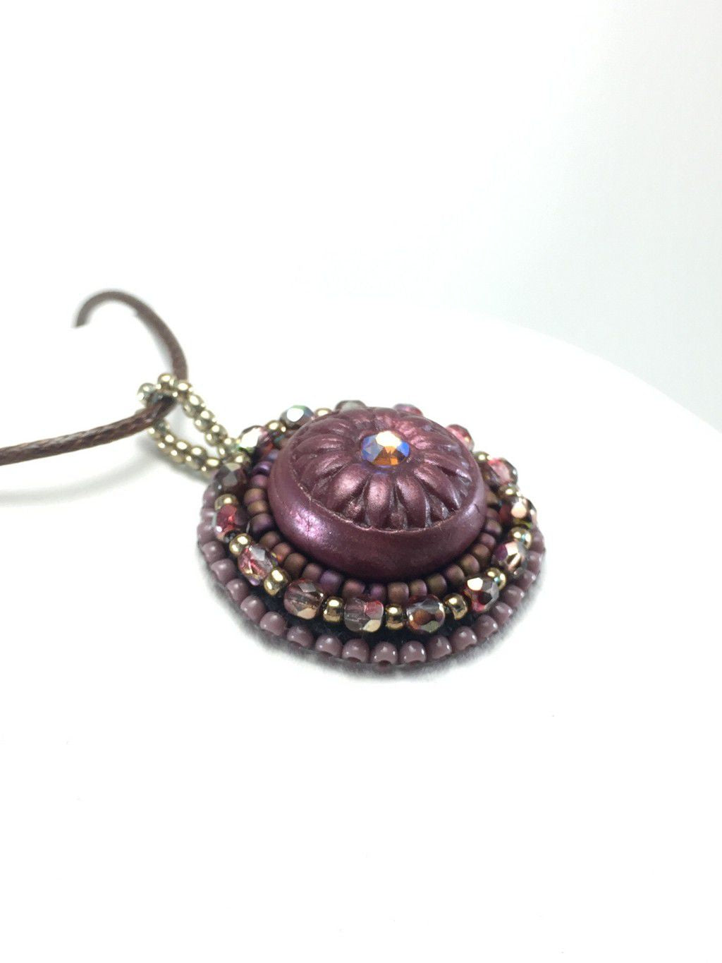 Tidy burgandy and gold daisy pendant with crystal center stone
