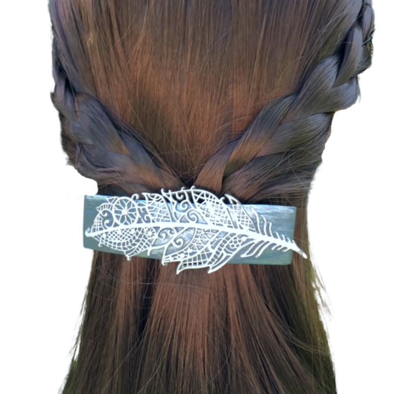 Silver blue polymer clay handmade hair barrette with silver clay mandala feather and crystals with rainbow luster dotted around the feather design in model's hair.