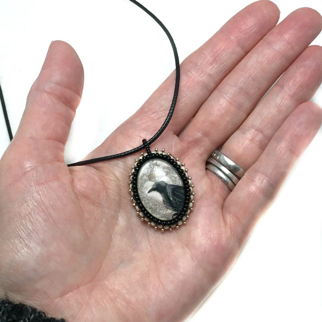 raven art necklace in hand
