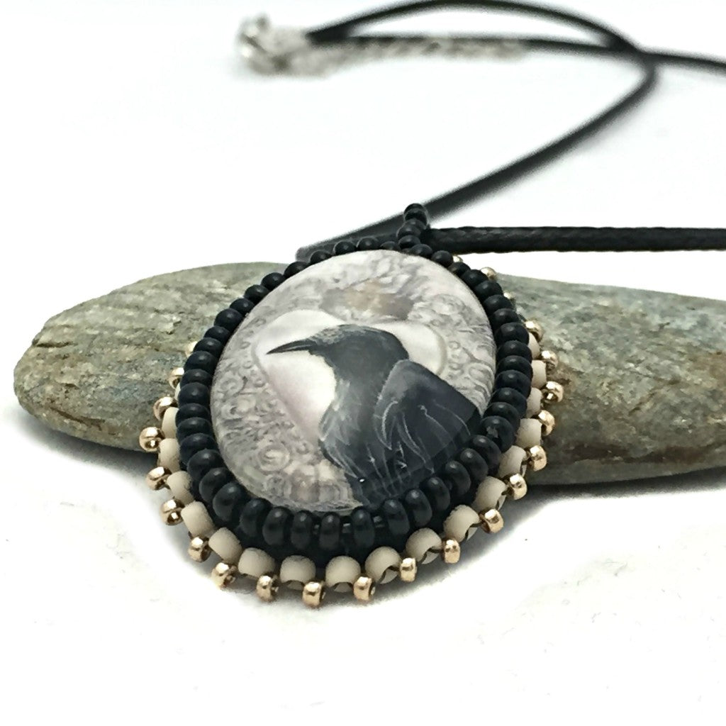 raven art necklace on rock