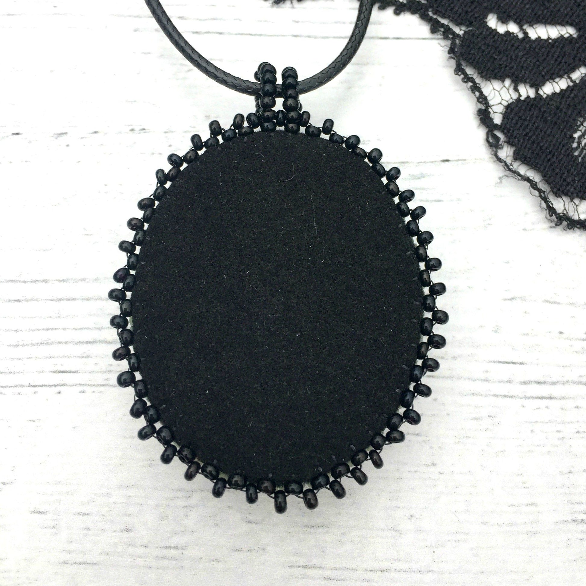 Back if raven necklace showing black faux suede.