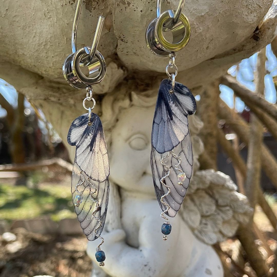 Double fairy wing earrings with silver accents, with ear tunnels for stretched ears.