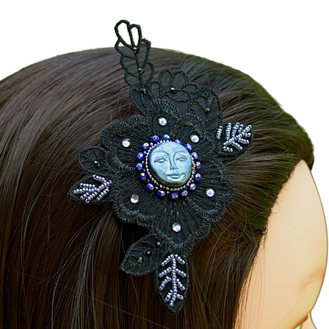 Side profile view of whimsigothic hair clip with blue moon and purple beading on black lace applique on a model.