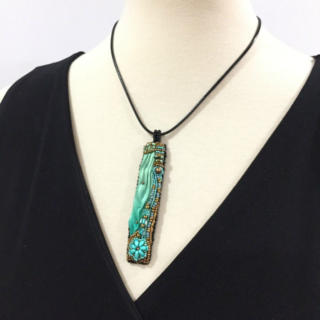 long green silk pendant on mannequin