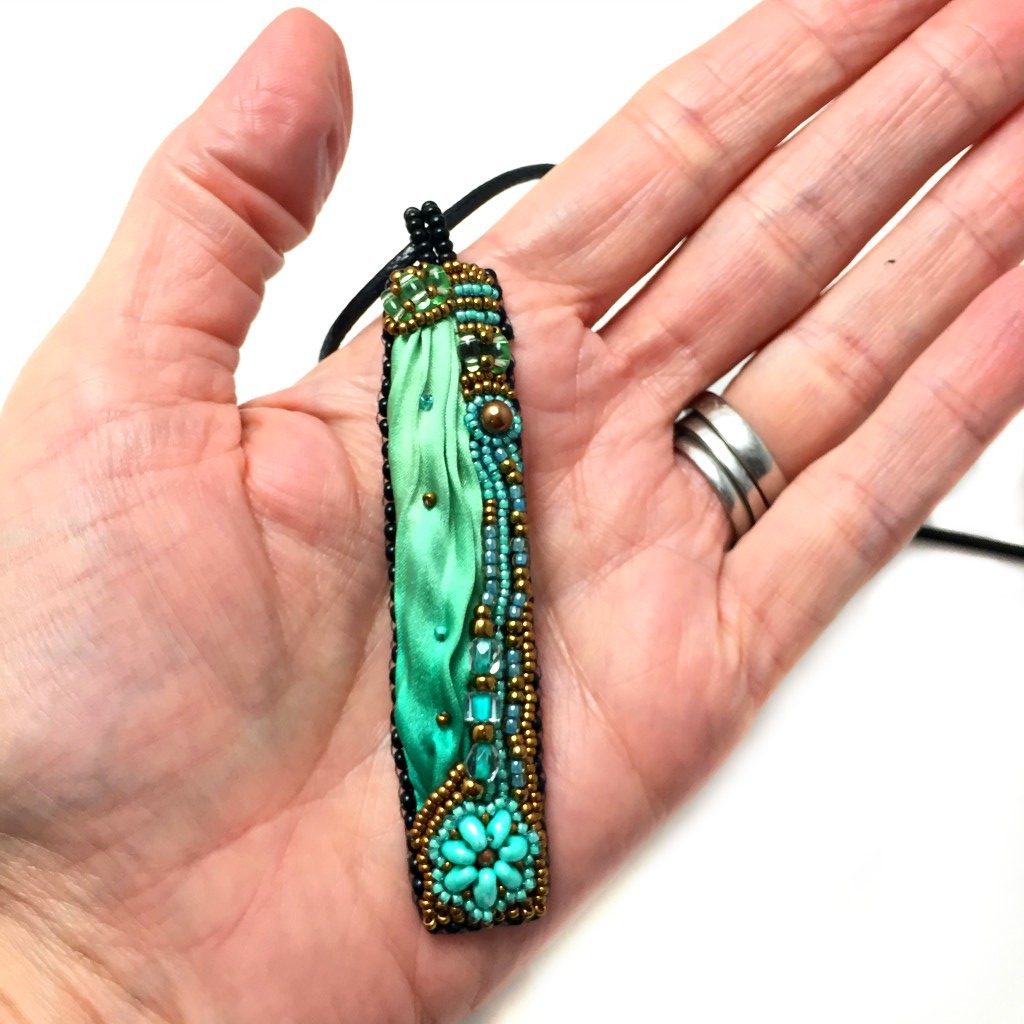 long green silk pendant in hand