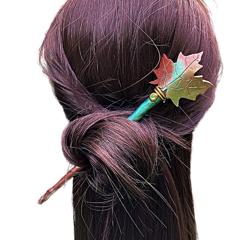 maple leaf hair pin on a mannequin with a hair bun