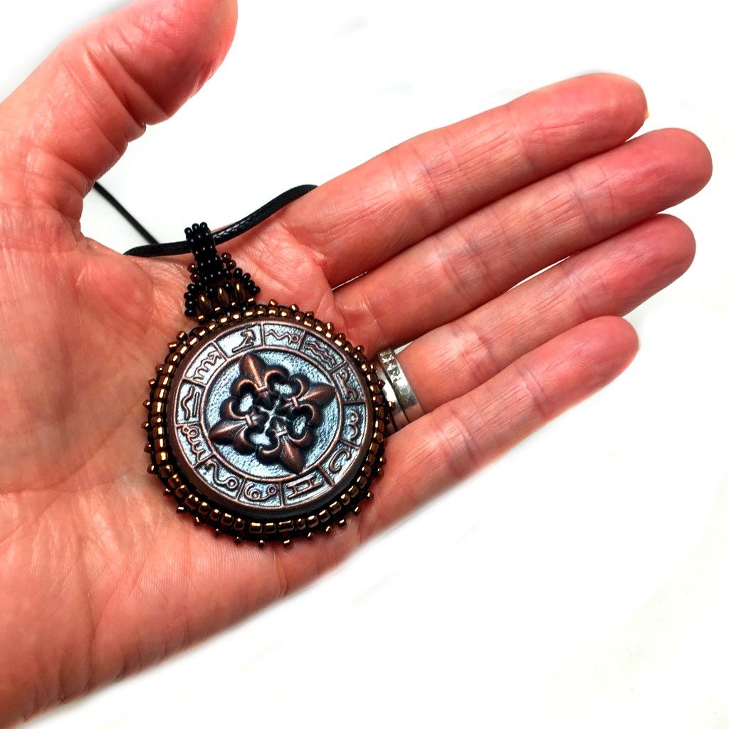 mayan bronze pendant in hand