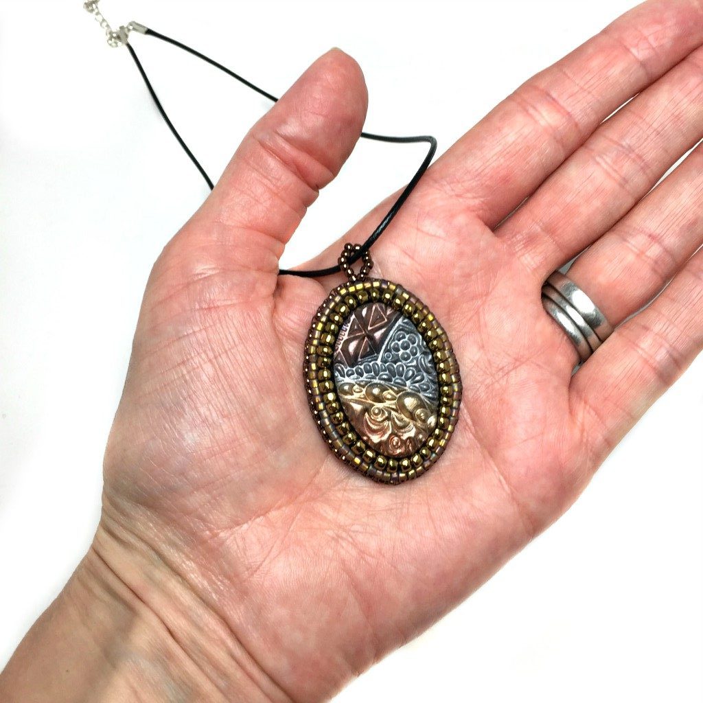 metallic zen tangle pendant in hand