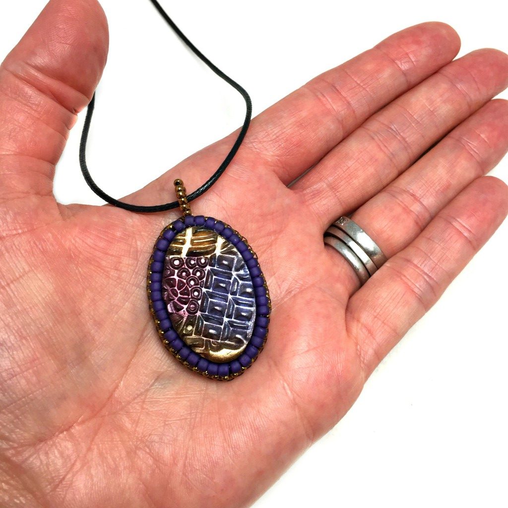 purple tangle art pendant in hand