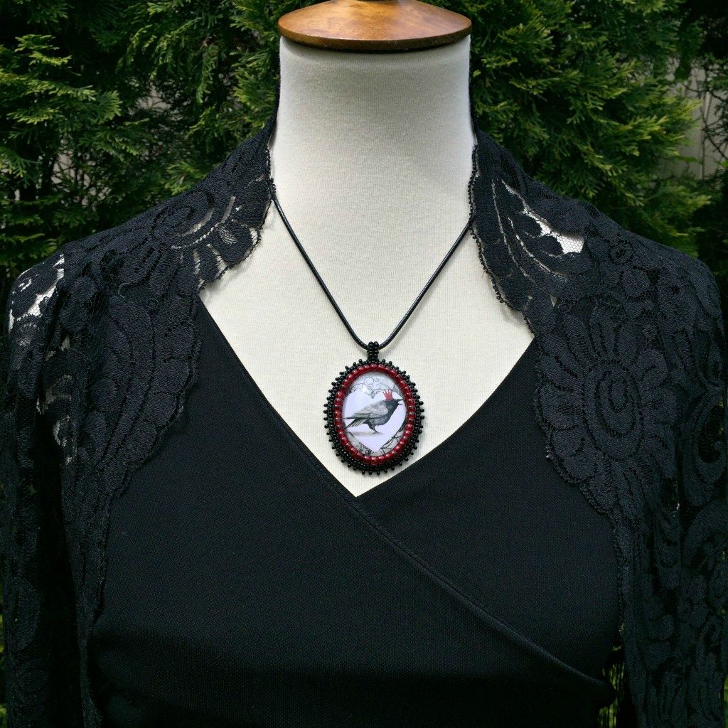 red crown raven pendant on mannequin