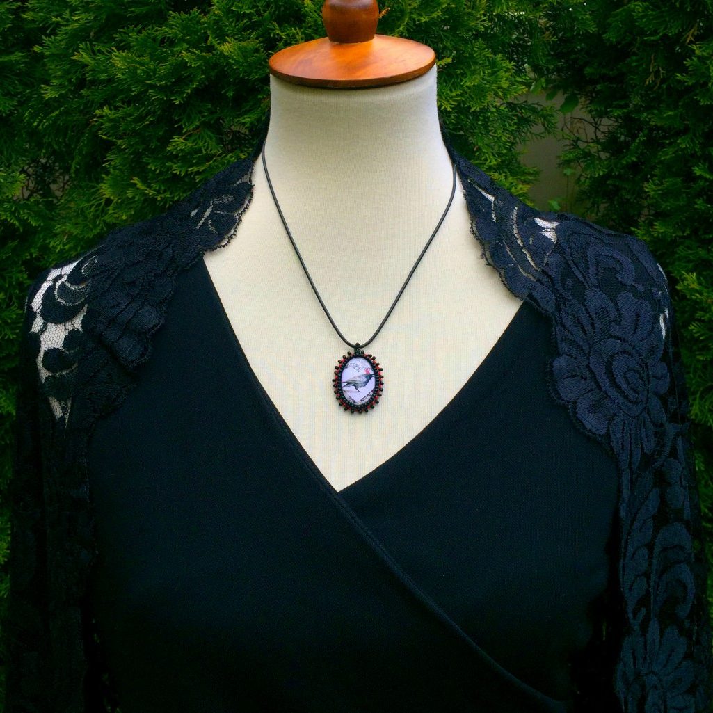 red crown raven beaded pendant on mannequin